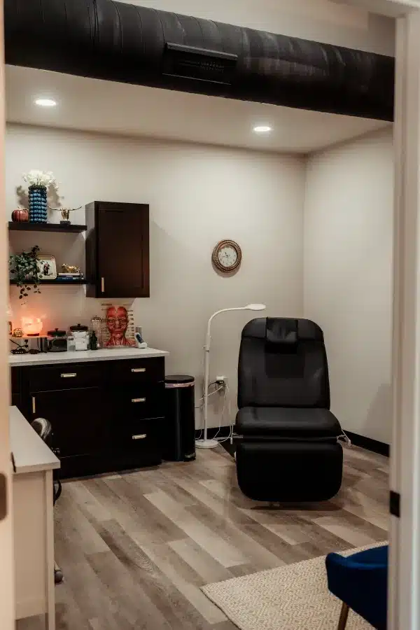Treatment room with reclining chair, exam lamp, and cabinetry at Loure Aesthetics